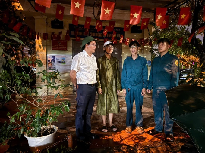 Chủ tịch UBND phường Giảng Võ Cồ Như Dũng (áo trắng) cùng dân quân trao đổi phương án chốt trực bảo đảm an ninh, an toàn khu chung cư cũ khi người dân di dời tạm.