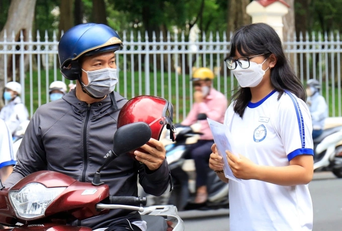 Phụ huynh TP HCM đưa con đến điểm thi tốt nghiệp THPT, tháng 6. Ảnh: Nguyệt Minh